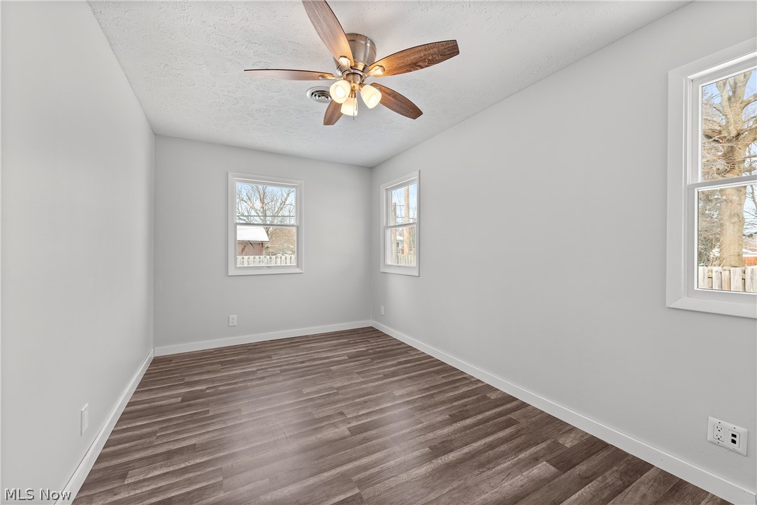 8760 Priem Road Strongsville, OH 44149 - Photo 27 of 29 Empty room with dark hardwood / wood-style floors, a textured ceiling, and ceiling fan