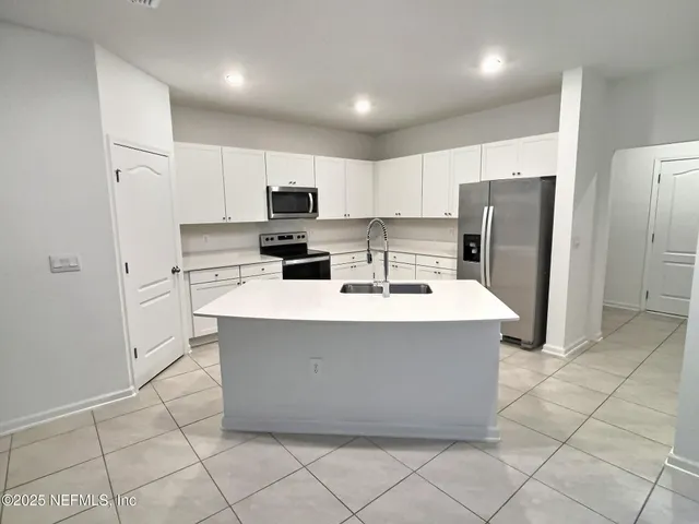 a kitchen with stainless steel appliances a refrigerator sink and cabinets