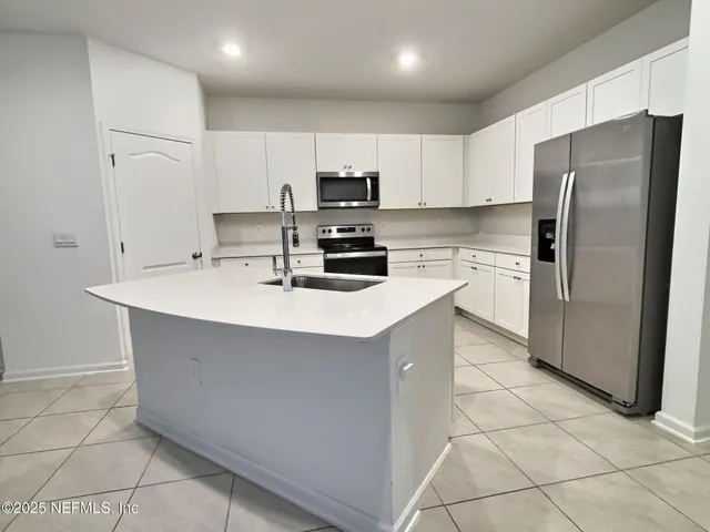 a kitchen with stainless steel appliances a refrigerator sink and microwave