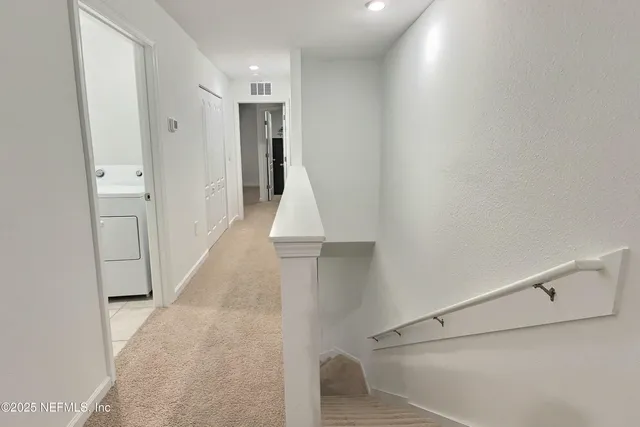 a view of a hallway with white walls