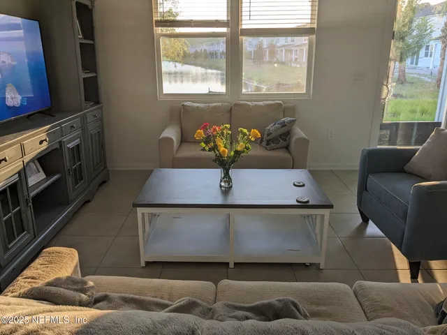 a living room with furniture a window and a flat screen tv