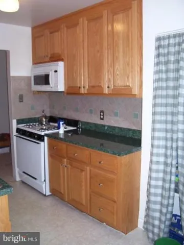 a kitchen with granite countertop a sink and a stove