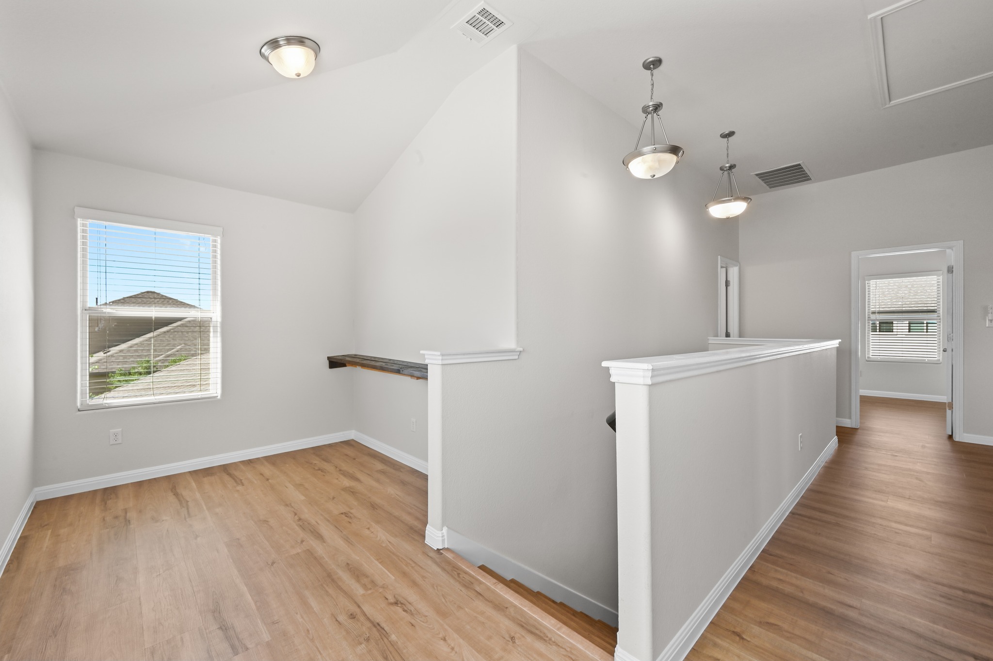 351 Wincliff Drive Buda, TX 78610 - Photo 26 of 40 A well-lit landing area with vaulted ceilings and vinyl flooring offers a versatile space.