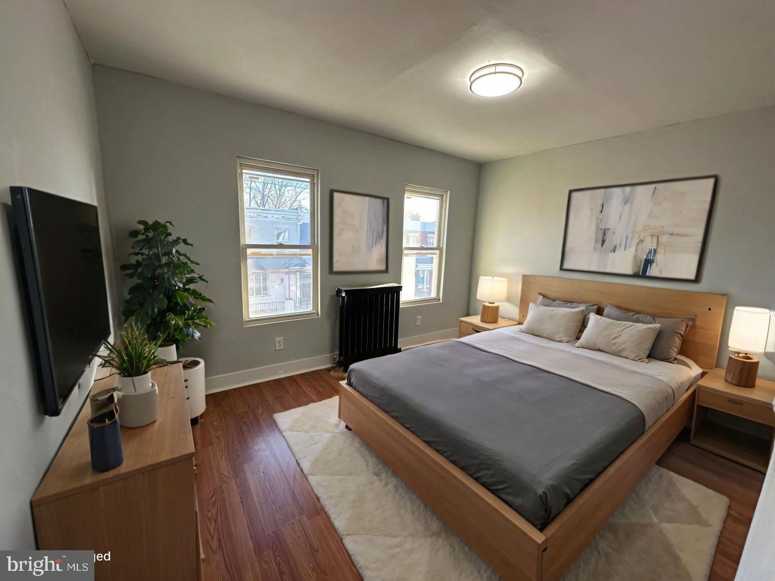 1922 Ruan Street Philadelphia, PA 19124 - Photo 2 of 11 a bedroom with a large bed and a flat tv screen on a dresser