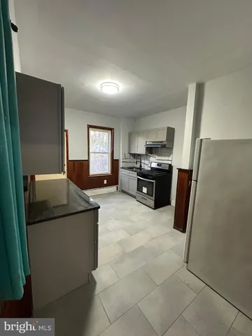 a kitchen with stainless steel appliances granite countertop a refrigerator a stove a sink a microwave and a refrigerator