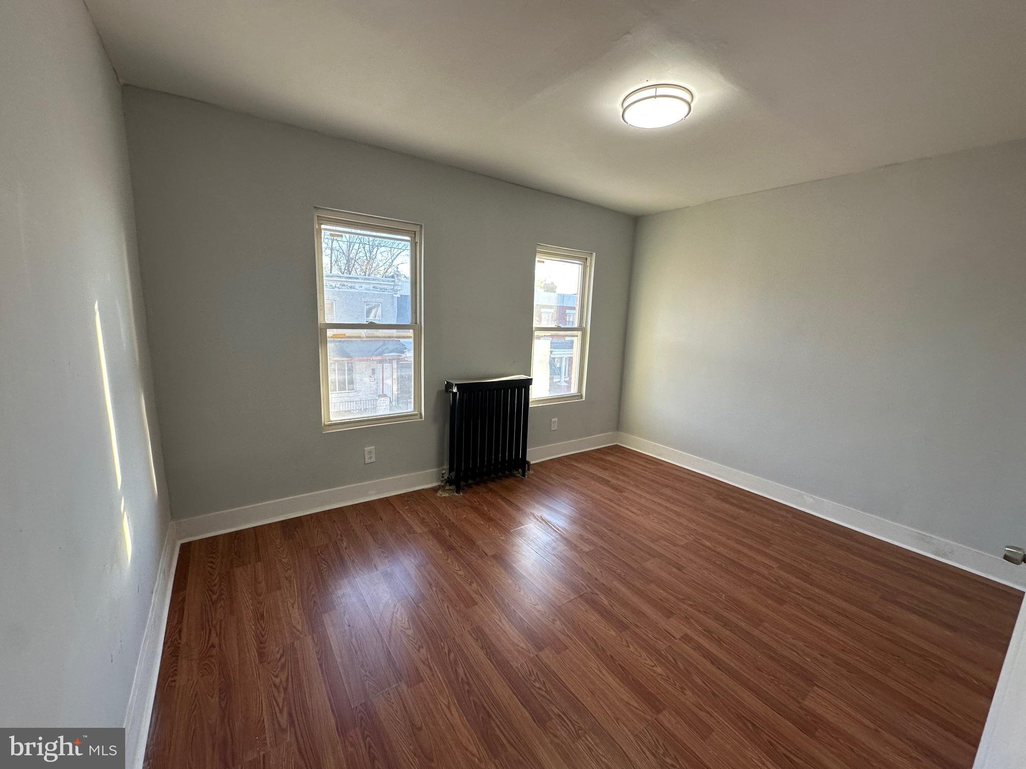 1922 Ruan Street Philadelphia, PA 19124 - Photo 10 of 11 an empty room with wooden floor and windows