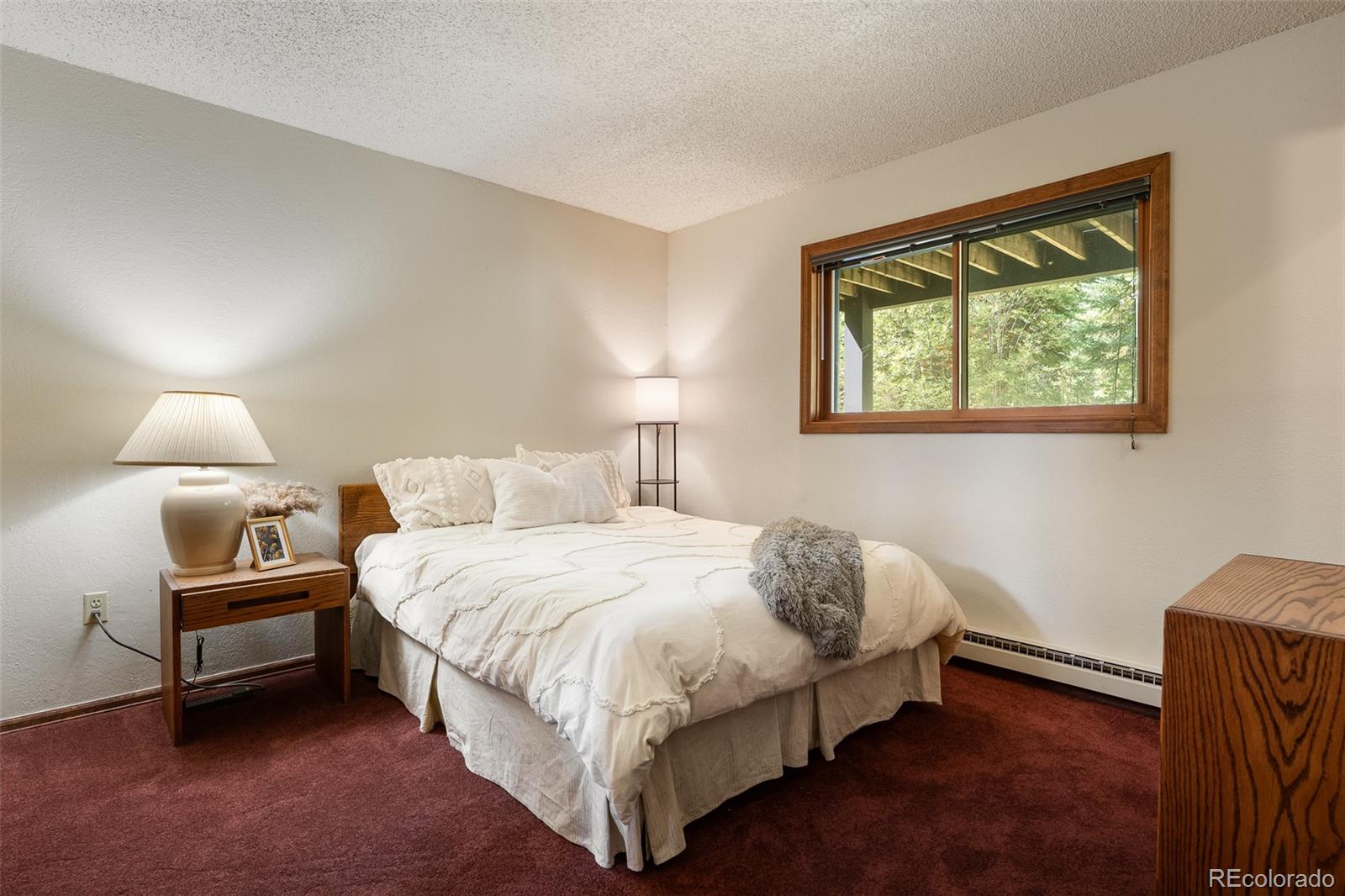 300 Kings Crossing Road, Unit B3 Winter Park, CO 80482 - Photo 24 of 38 a bedroom with a bed lamp and window