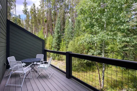 a view of trees and deck with patio