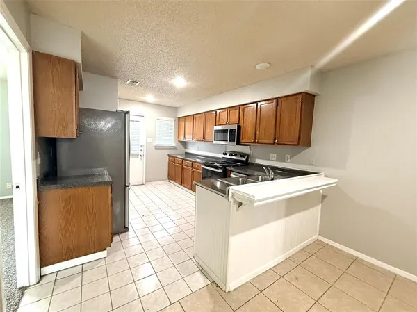a kitchen with stainless steel appliances granite countertop a stove a refrigerator and a sink