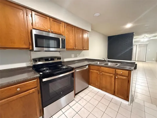 a kitchen with stainless steel appliances granite countertop a sink stove and microwave