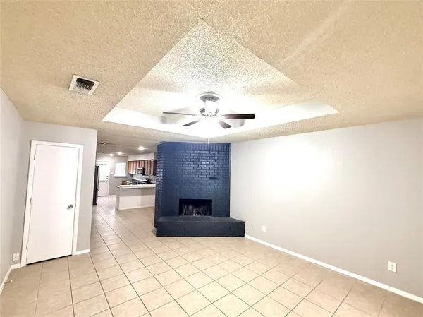 en empty room with windows and ceiling fan