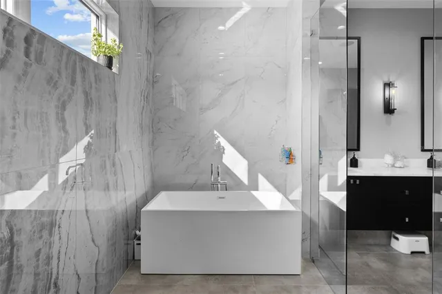 a bedroom with a bed a couch and a flat tv screen