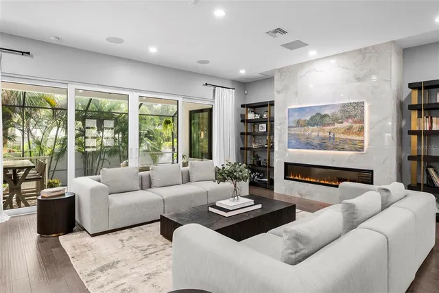 a living room with furniture kitchen area and a large window