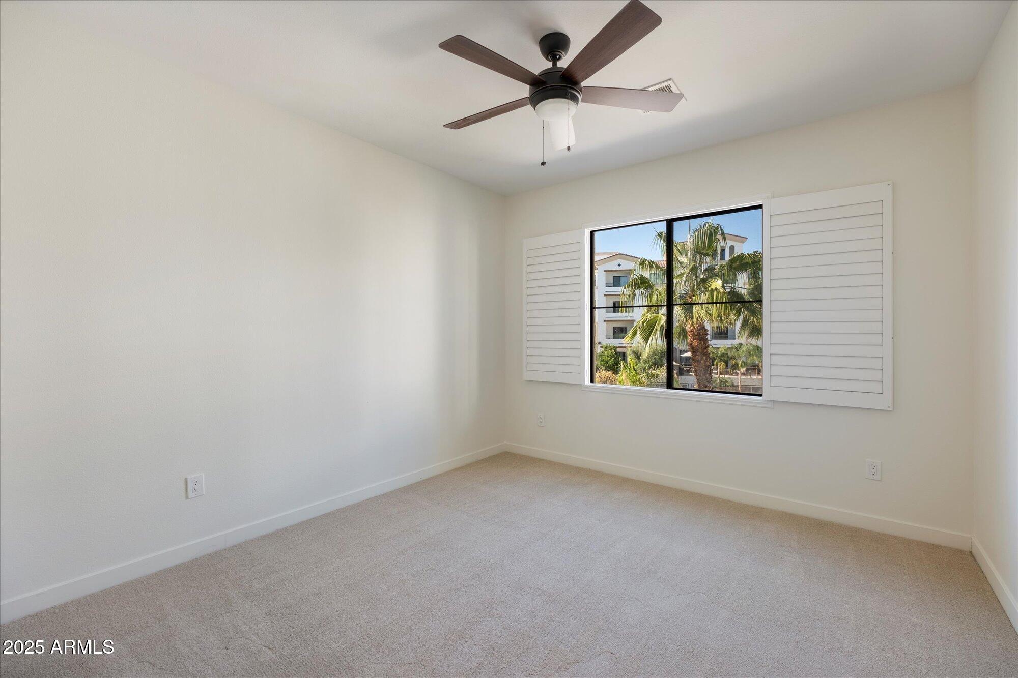 2511 West Queen Creek Road, Unit 230 Chandler, AZ 85248 - Photo 13 of 37 an empty room with windows and ceiling fan