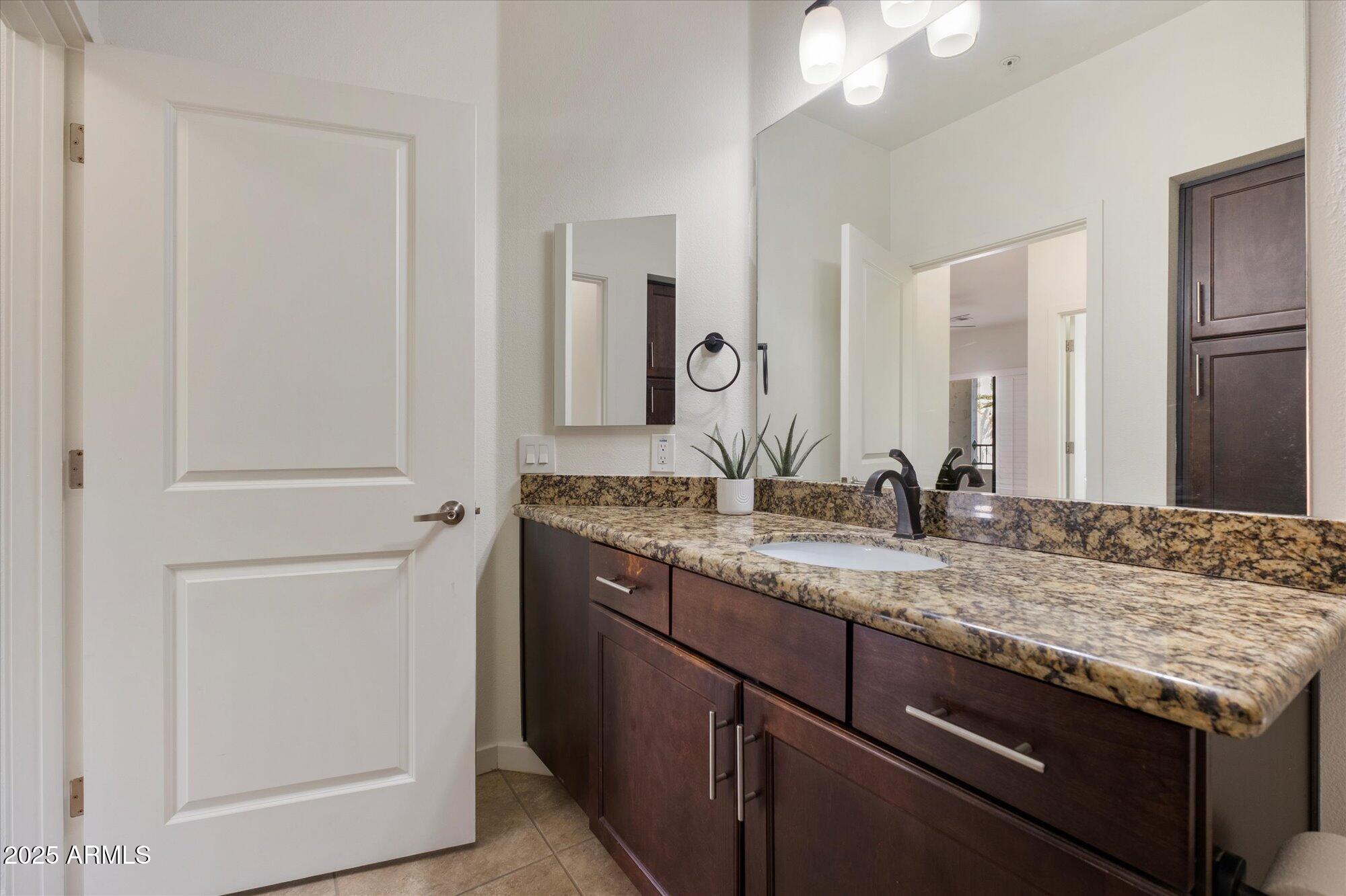 2511 West Queen Creek Road, Unit 230 Chandler, AZ 85248 - Photo 15 of 37 a bathroom with a granite countertop sink and a mirror