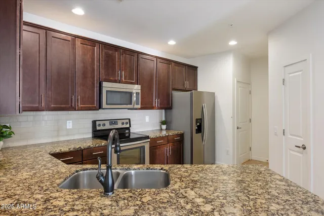 a kitchen with granite countertop wooden cabinets and stainless steel appliances