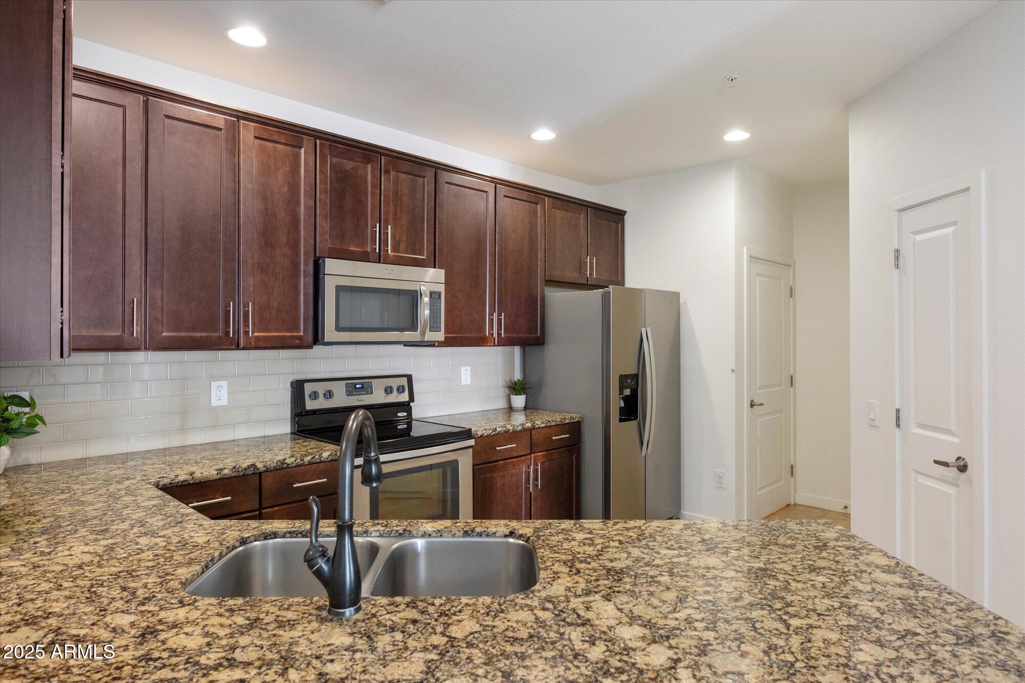 2511 West Queen Creek Road, Unit 230 Chandler, AZ 85248 - Photo 5 of 37 a kitchen with stainless steel appliances granite countertop a refrigerator and a sink