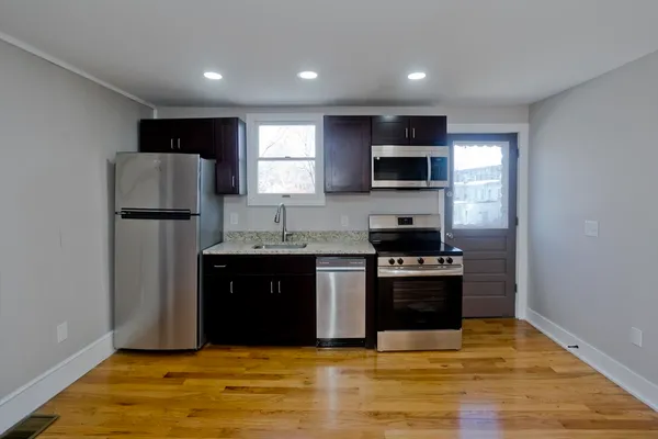 a kitchen with stainless steel appliances granite countertop a refrigerator and a stove top oven