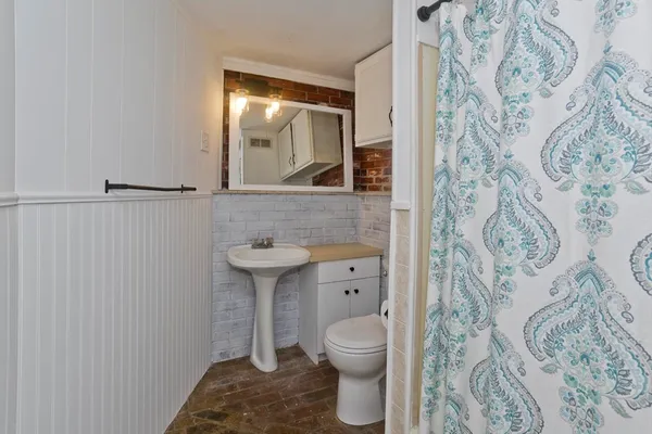 a bathroom with a toilet sink and mirror