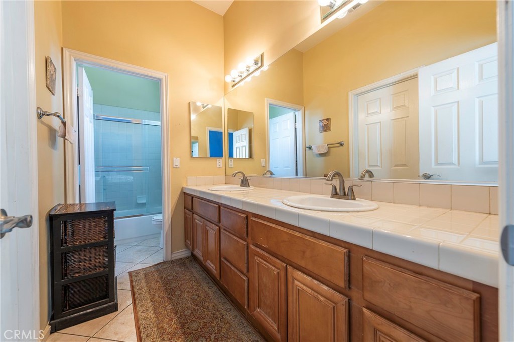 10281 Hillside Road Rancho Cucamonga, CA 91737 - Photo 33 of 60 a bathroom with a double vanity sink and a mirror