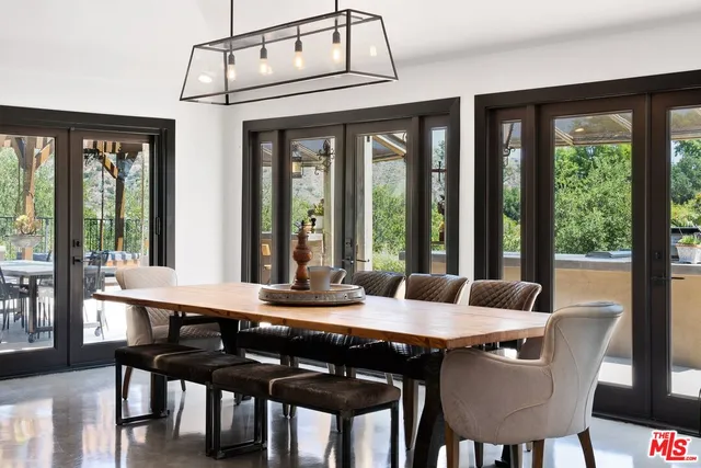 a view of a dining room with furniture large windows and wooden floor