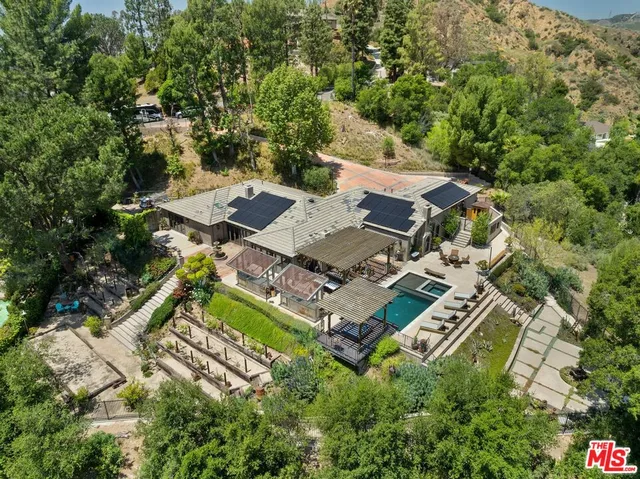 an aerial view of residential houses with outdoor space and trees