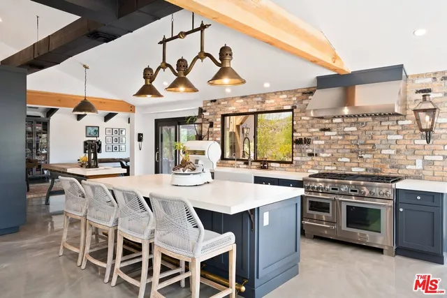 a kitchen with stainless steel appliances a stove a table and chairs