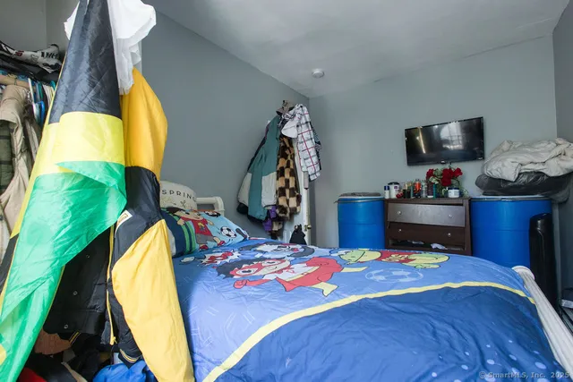 a bedroom with a bed and a lamp on dresser