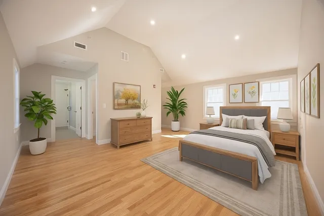 a spacious bedroom with a large bed a potted plant and attached bathroom