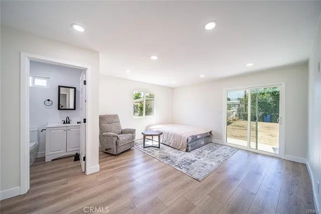 a spacious bedroom with a bed and wooden floor