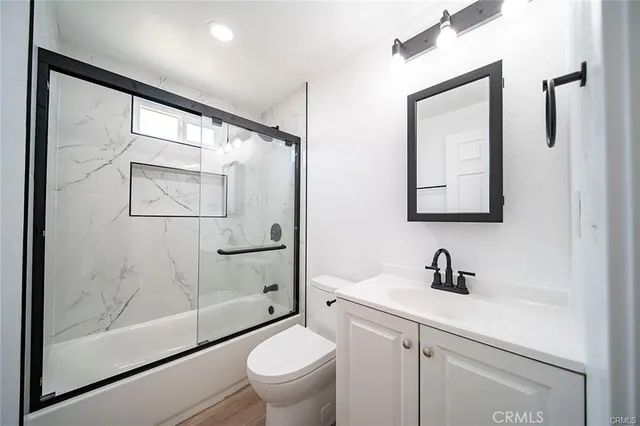 a bathroom with a sink a mirror a toilet and shower