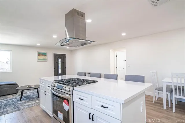 a kitchen with a stove a chandelier and a refrigerator