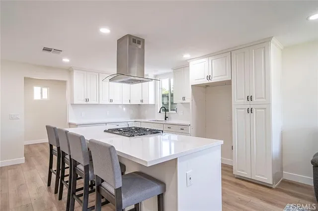 a kitchen with stainless steel appliances a table chairs and a refrigerator