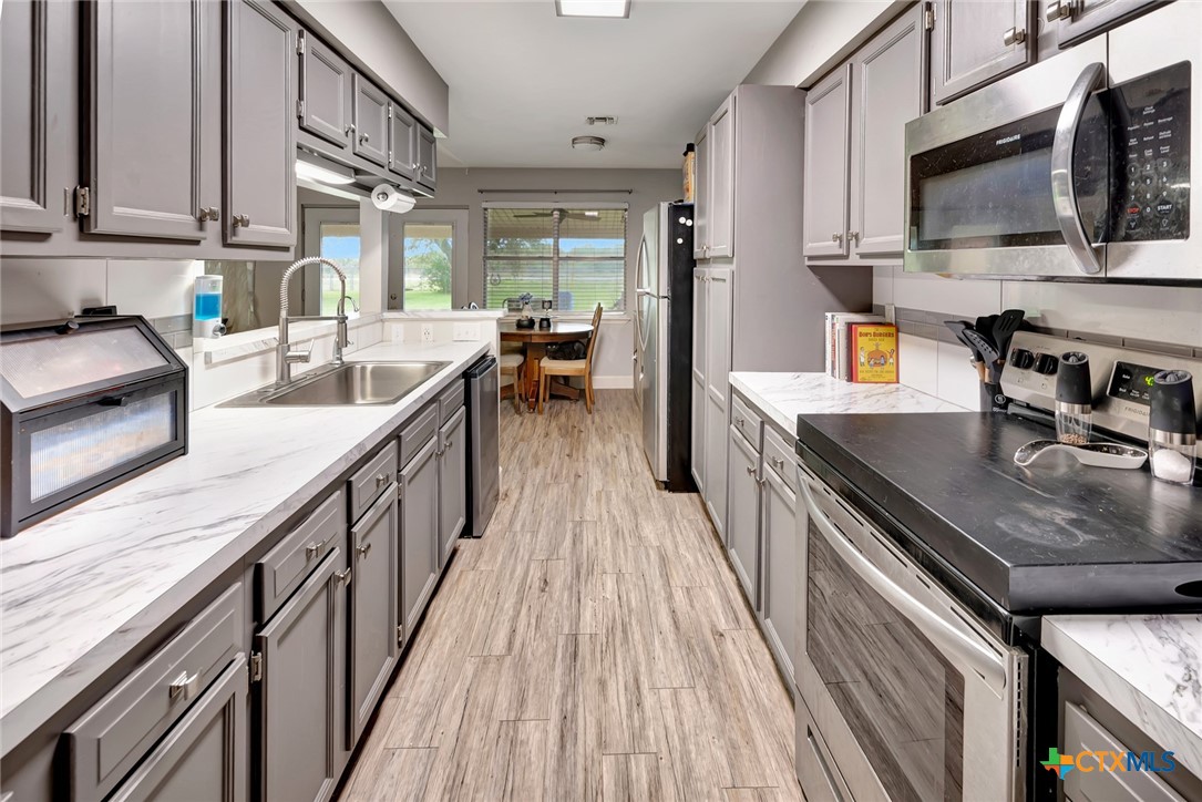 401 Viking Street Victoria, TX 77905 - Photo 7 of 20 a kitchen with stainless steel appliances granite countertop a lot of counter space and wooden floors
