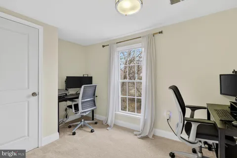 a view of a workspace with furniture and a window