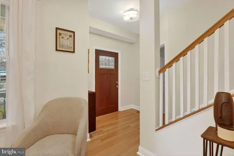 a view of hallway with furniture and wooden floor