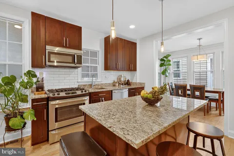 a kitchen with sink stove microwave and cabinets
