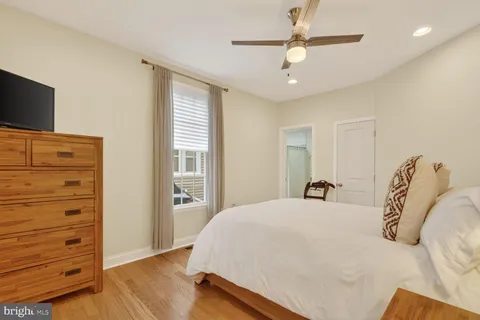 a bedroom with a bed and a flat tv screen on dresser