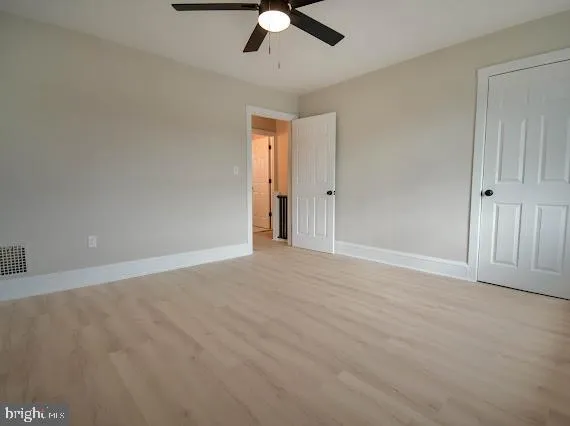 an empty room with a window and a fan