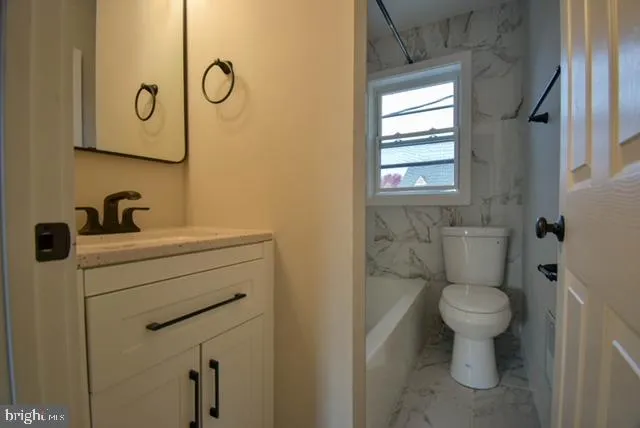 a view of an empty room and chandelier fan