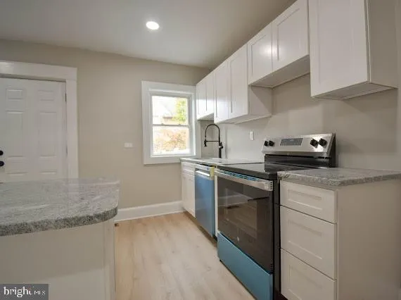 a kitchen with white cabinets and white appliances