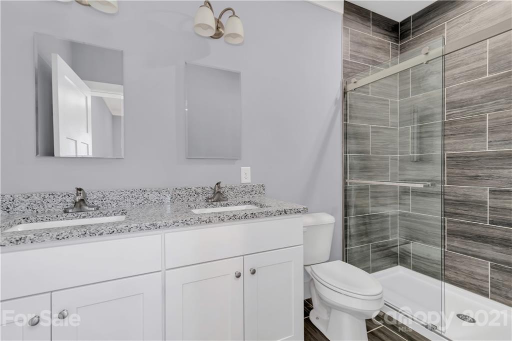 349 Ridge View Drive, Unit 3 Clyde, NC 28721 - Photo 14 of 20 a bathroom with a granite countertop toilet sink and mirror