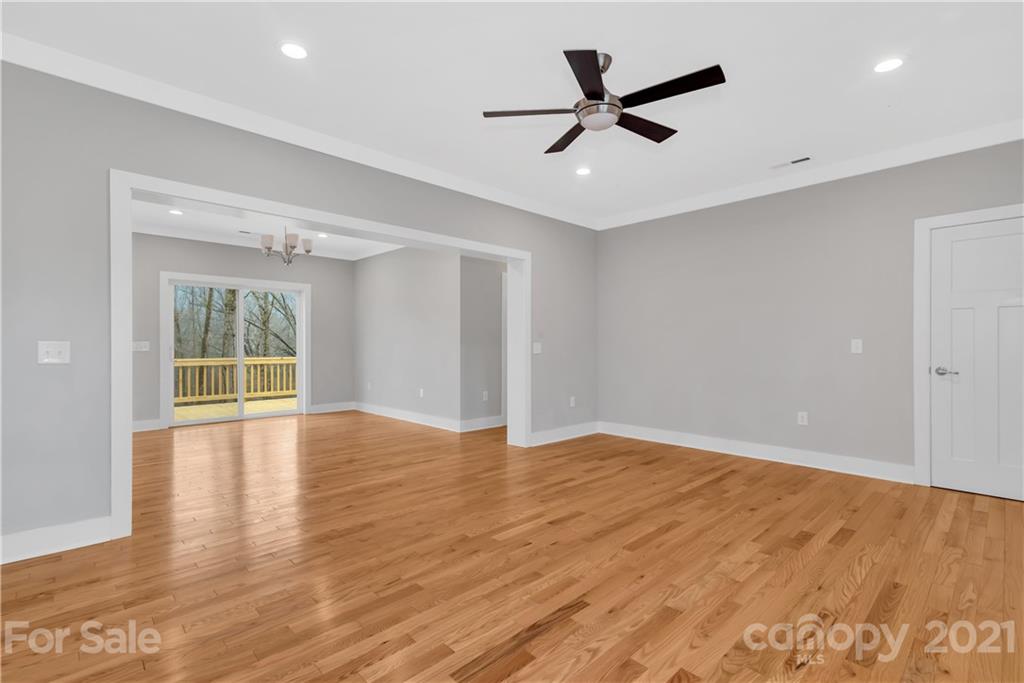 349 Ridge View Drive, Unit 3 Clyde, NC 28721 - Photo 6 of 20 a view of empty room with wooden floor and ceiling fan