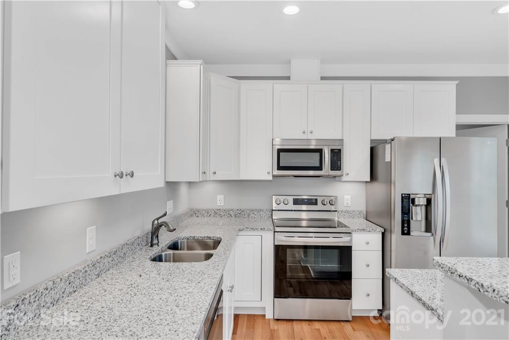 349 Ridge View Drive, Unit 3 Clyde, NC 28721 - Photo 9 of 20 a kitchen with stainless steel appliances granite countertop a stove a sink and a refrigerator