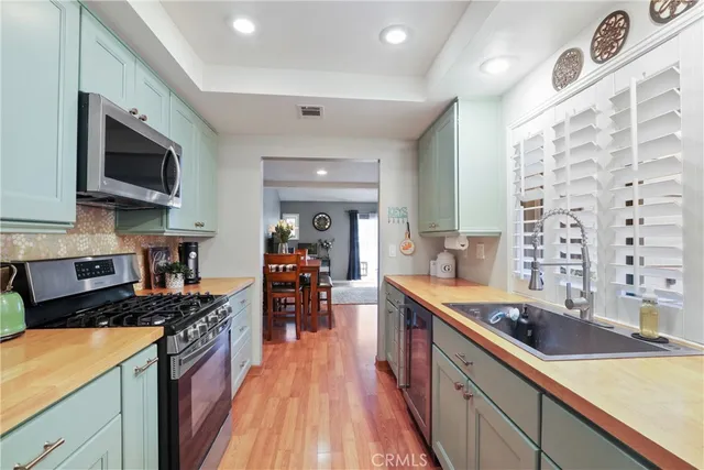 a large kitchen with stainless steel appliances granite countertop a lot of counter space and wooden floor