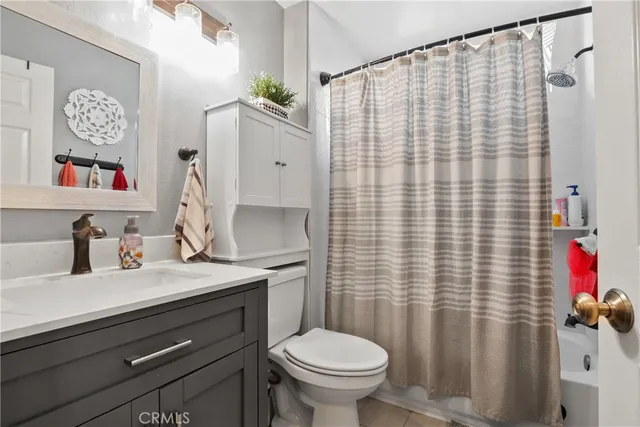 a bathroom with a sink a toilet and a shower curtain