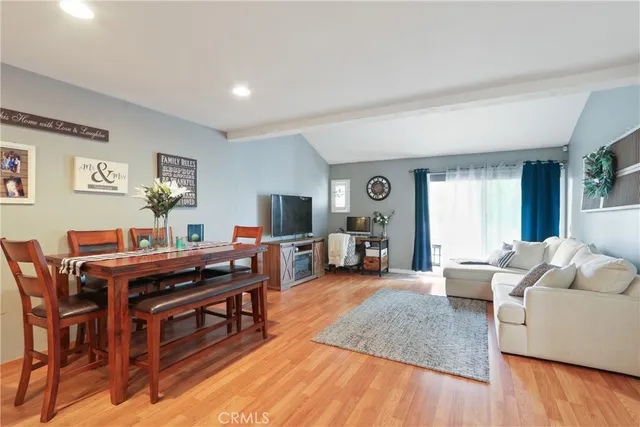 a living room with furniture and a flat screen tv with wooden floor