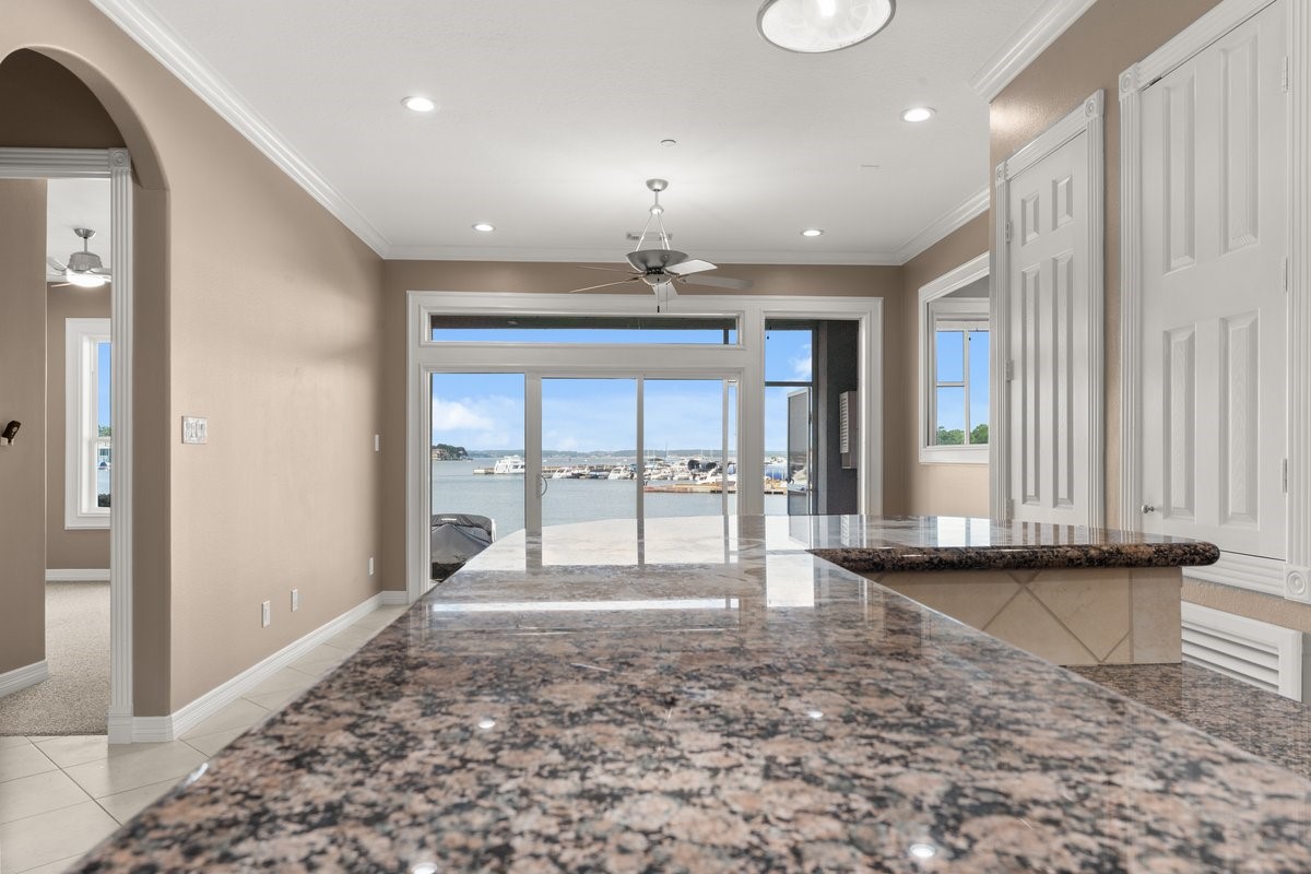 168 Lake Point Boulevard, Unit C102 Conroe, TX 77356 - Photo 4 of 35 This spacious home features an open layout with a kitchen view extending to a waterfront vista. Granite countertops and large windows enhance natural light and provide a stunning marina backdrop.