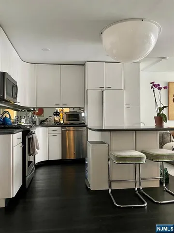 a kitchen with granite countertop a sink cabinets and stainless steel appliances