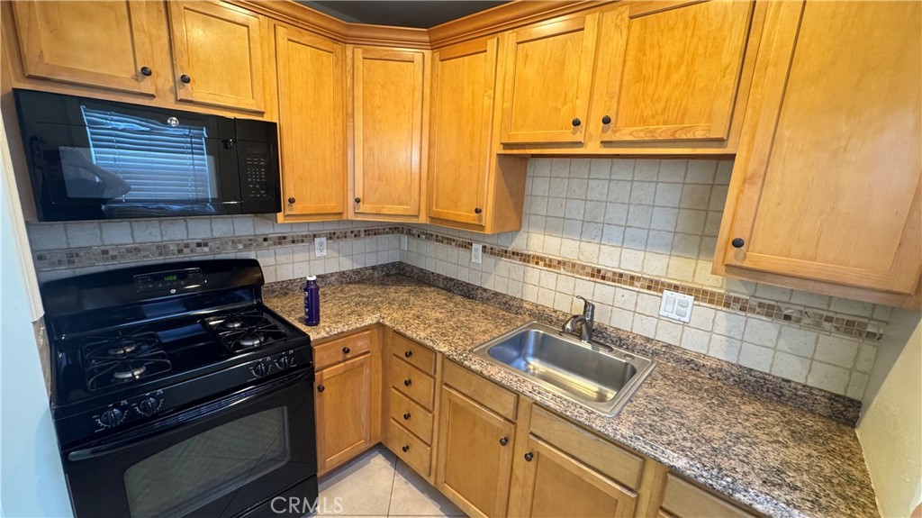 911 Genoa Street, Unit A Monrovia, CA 91016 - Photo 4 of 9 a kitchen with granite countertop a sink a stove and cabinets